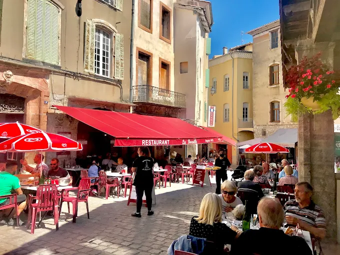 La grande terrasse ensoleillée sous les stores rouges